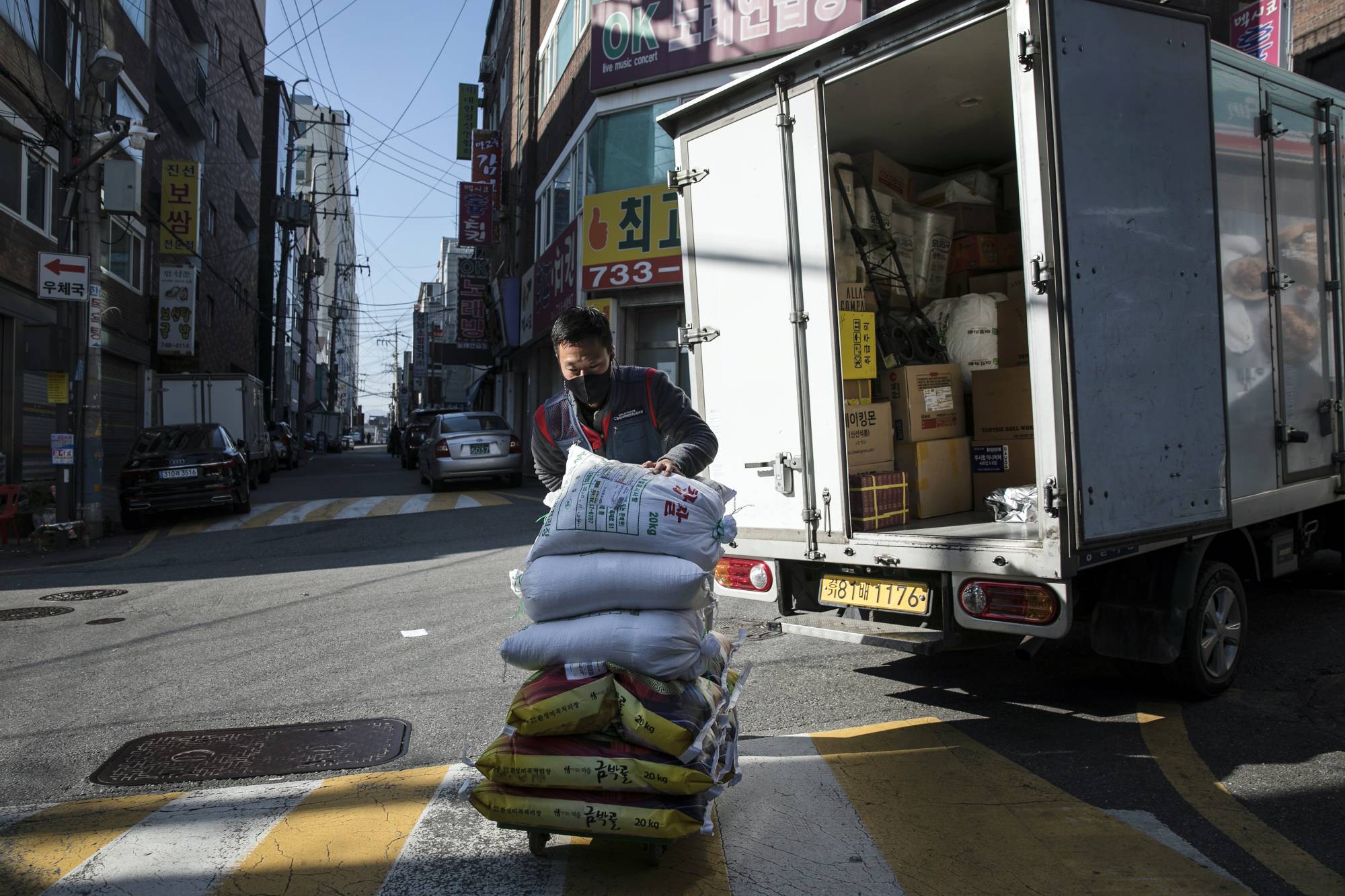 Park Ki-Ryeon delivers bags of rice to customers in Seongnam, a city on the outskirts of Seoul, late last month.  | WOOHAE CHO / THE NEW YORK TIMES