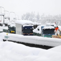 Vehicles are stranded on the Kan-Etsu Expressway in Minamiuonuma, Niigata Prefecture, on Friday morning as heavy snow hit a wide area along the Sea of Japan coast. | KYODO