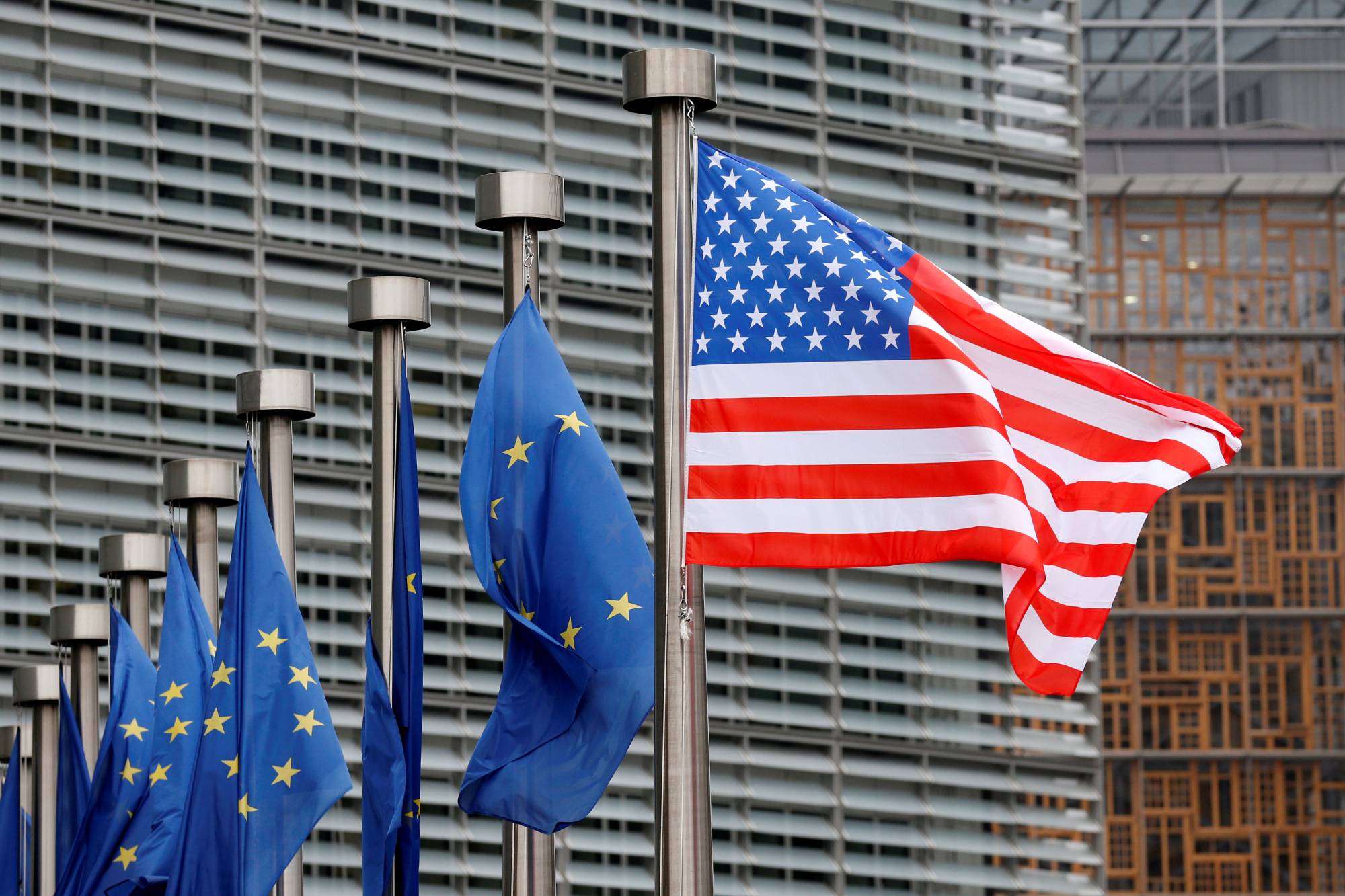The U.S. flag is flown outside the European Commission headquarters in Brussels. New EU regulations designed to curtail the power of Big Tech, will have a far-reaching impact on the business practices of Apple, Amazon, Facebook, Google and other primarily U.S.-based giants. | REUTERS