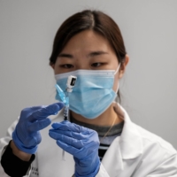 A pharmacist measures doses of a COVID-19 vaccine at the Virginia Hospital Center in Arlington, on Wednesday. A deep distrust of the government is fueling vaccine hesitancy among Republicans, who are more likely than Democrats to resist being inoculated against COVID-19.  | MICHAEL A. MCCOY/THE NEW YORK TIMES