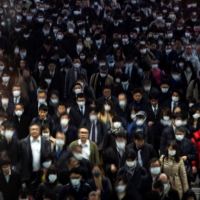 Commuters walk through Shinagawa Station in Tokyo on March 2. | REUTERS