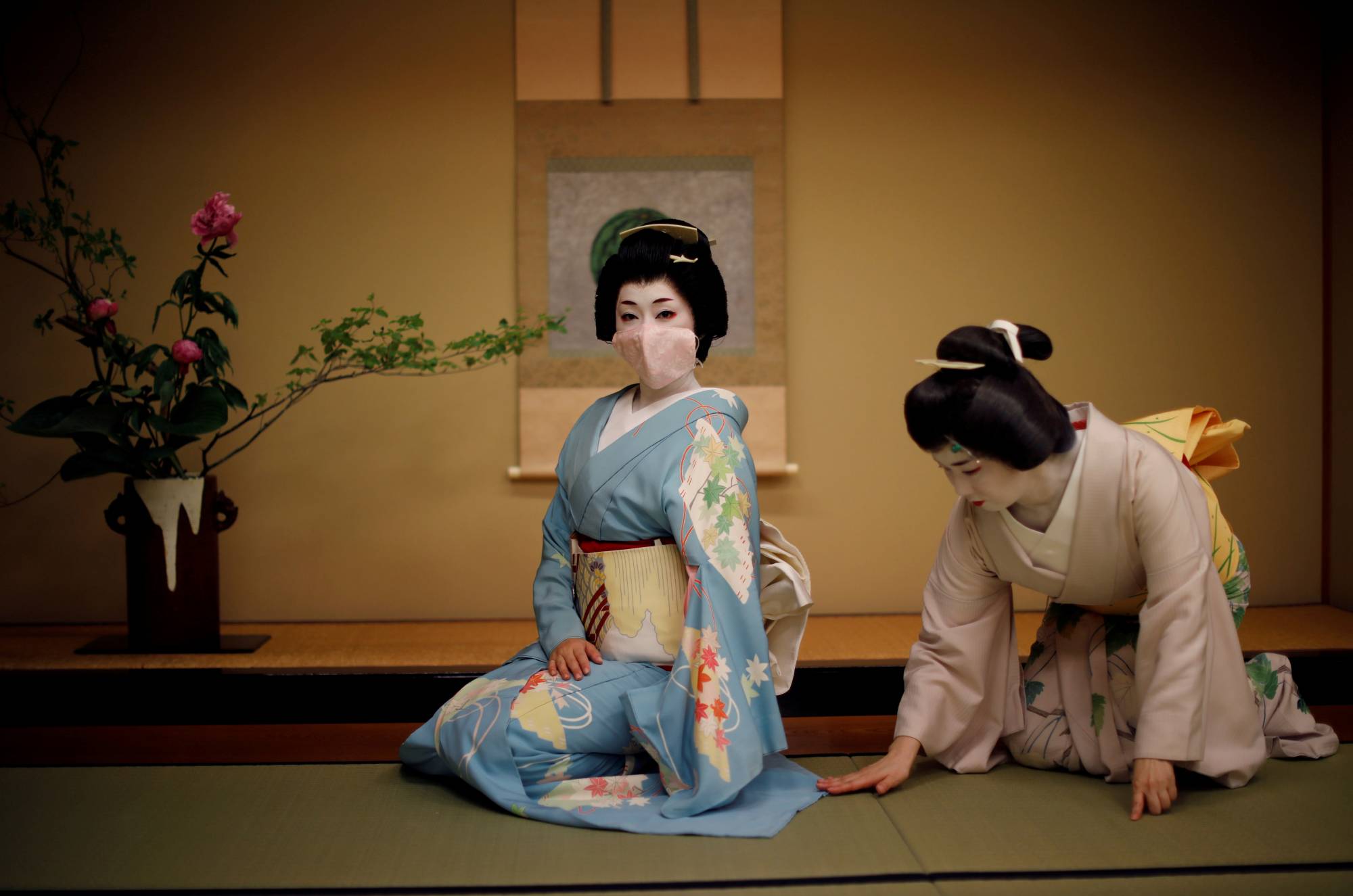 A geisha wears a protective face mask to pose for a photograph before performing at a party at luxury Japanese restaurant Asada during the COVID-19 outbreak in Tokyo on June 23. | REUTERS