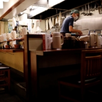Yashiro Haga works in the kitchen of his empty ramen shop following the COVID-19 outbreak in Tokyo on Dec. 10. | REUTERS