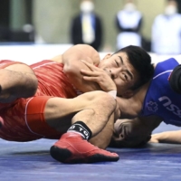 Kenichiro Fumita (left) attacks Ayata Suzuki in the 60-kg Greco-Roman final during the national wrestling championships at Komazawa Gymnasium on Sunday. | POOL / VIA KYODO