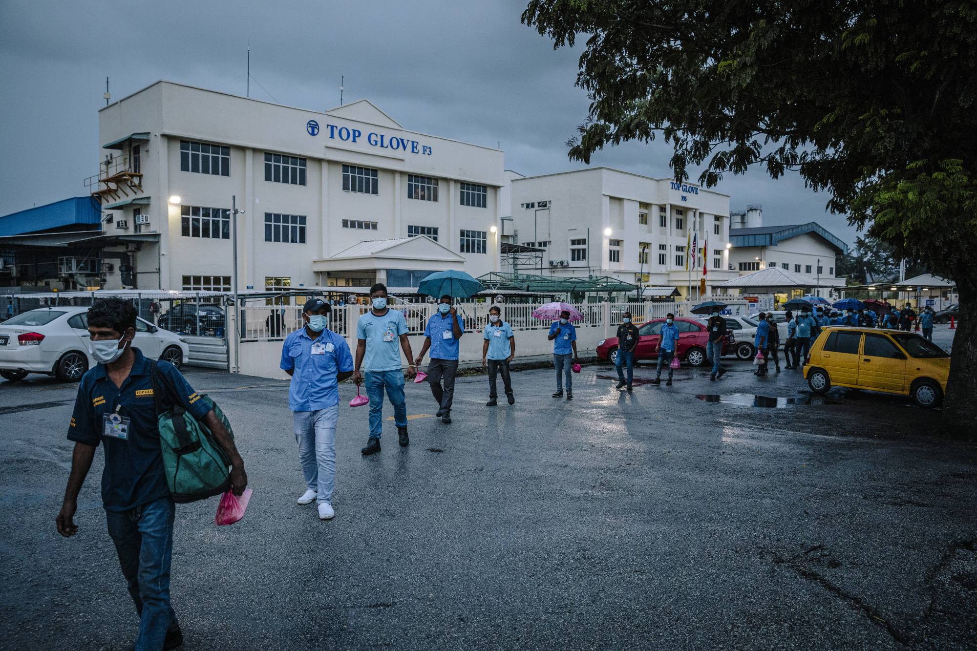 Top Glove employees leave after a shift at the company's factory in Klang, Malaysia, on Dec. 14. | The New York Times