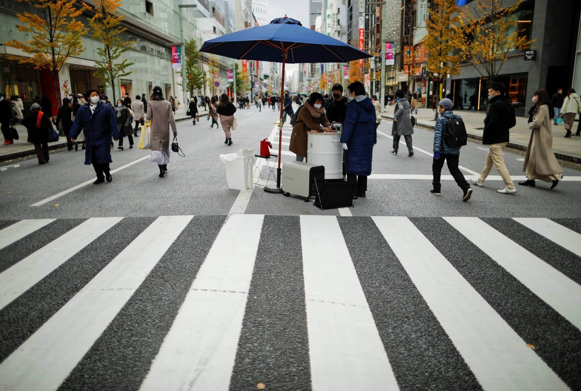 A shopper washes her hands using a mobile handwashing machine called Wosh, installed to prevent the spread of COVID-19, in the Ginza shopping district of Tokyo on Saturday. | REUTERS