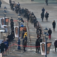 People wait in line to take COVID-19 tests in Seoul on Tuesday.  | AFP-JIJI