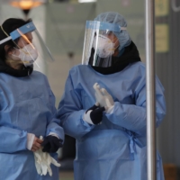 Medical workers at a testing site in Seoul on Monday.  | AP