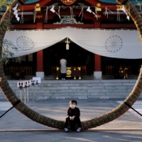 A boy sits on decorations for the New Year\'s holiday period at a Shinto shrine in Tokyo on Tuesday. Japan has one of the lowest rates of vaccine confidence in the world, according to a Lancet study, which found that fewer than 30% of people strongly agreed that vaccines were safe.  | REUTERS
