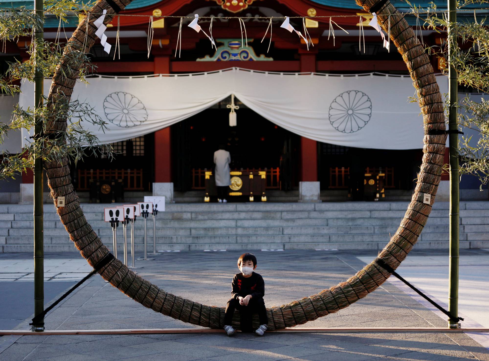 A boy sits on decorations for the New Year's holiday period at a Shinto shrine in Tokyo on Tuesday. Japan has one of the lowest rates of vaccine confidence in the world, according to a Lancet study, which found that fewer than 30% of people strongly agreed that vaccines were safe.  | REUTERS