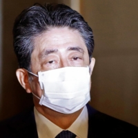 Former Prime Minister Shinzo Abe arrives at the Diet building in Tokyo on Friday to face questions over a possible violation of election funding laws. | REUTERS