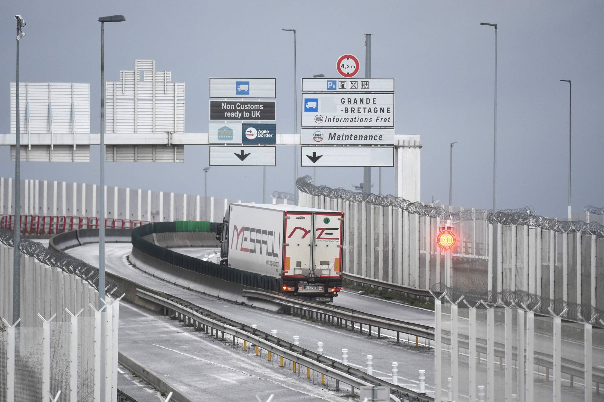 Trucks depart for England via the Channel Tunnel at the port of Calais on Friday. | AFP-JIJI