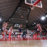 Kaishi Kokusai High School (in white) competes against Nobeoka Gakuen during the Winter Cup in Tokyo on Friday. The Niigata Prefecture school has been forced to withdraw from the tournament due to the event\'s coronavirus guidelines. | JBA
