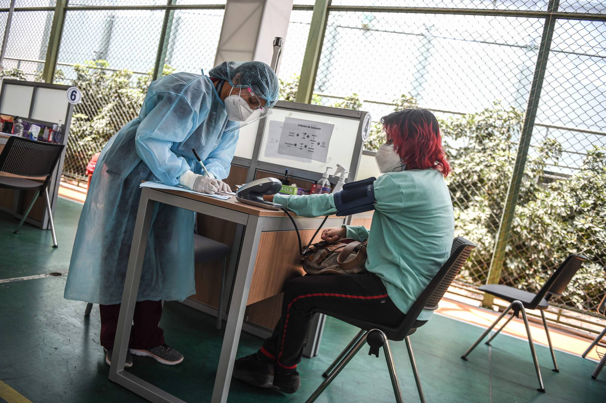 A volunteer is checked before receiving a COVID-19 vaccine produced by China's Sinopharm during its trial at the Clinical Studies Center of Cayetano Heredia University in Lima on Dec. 9.  | AFP-JIJI