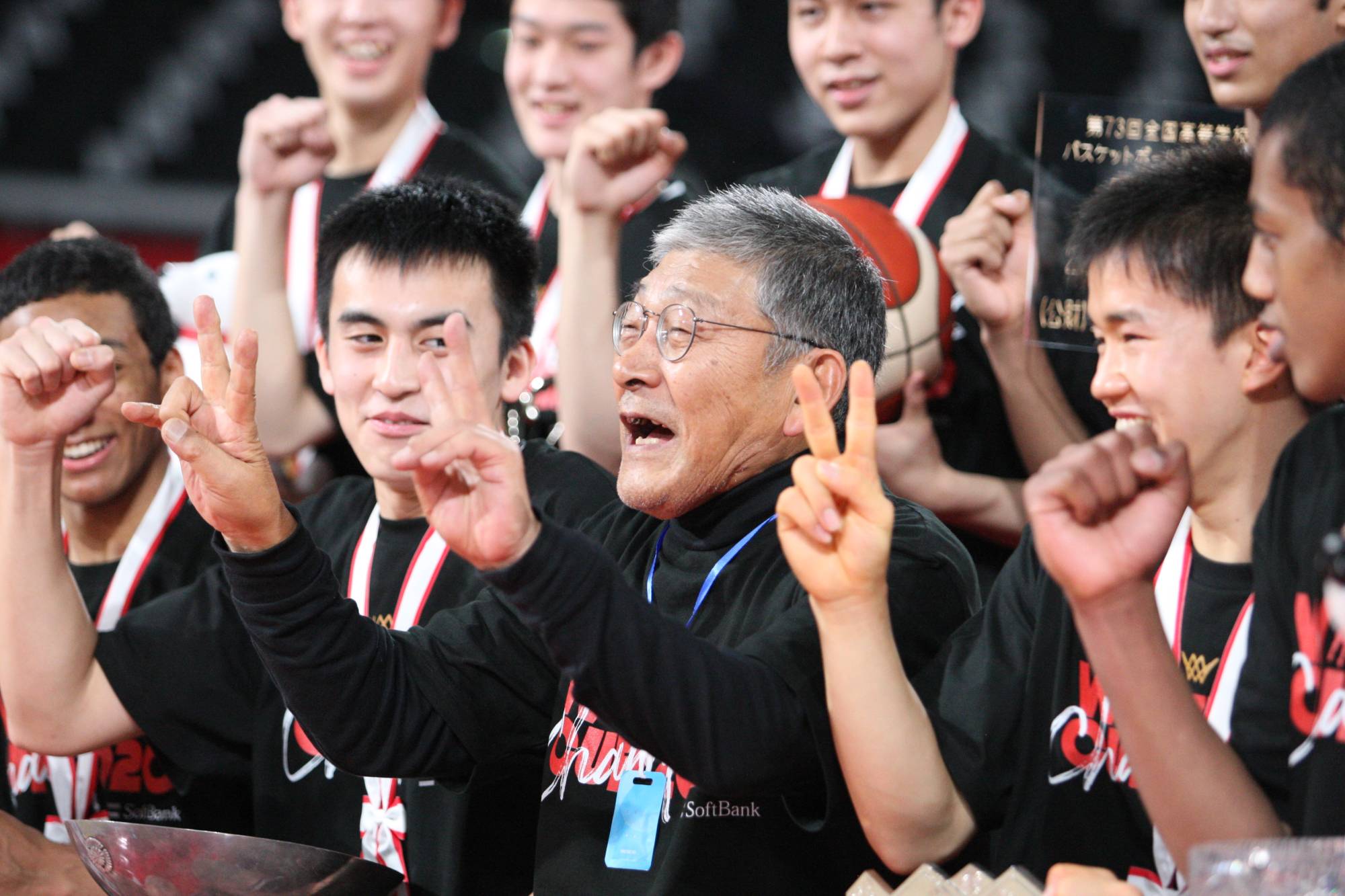 Meisei head Hisao Sato (center) celebrates with his players after Tuesday's win at Tokyo Metropolitan Gymnasium. | Courtesy of the Japan Basketball Association