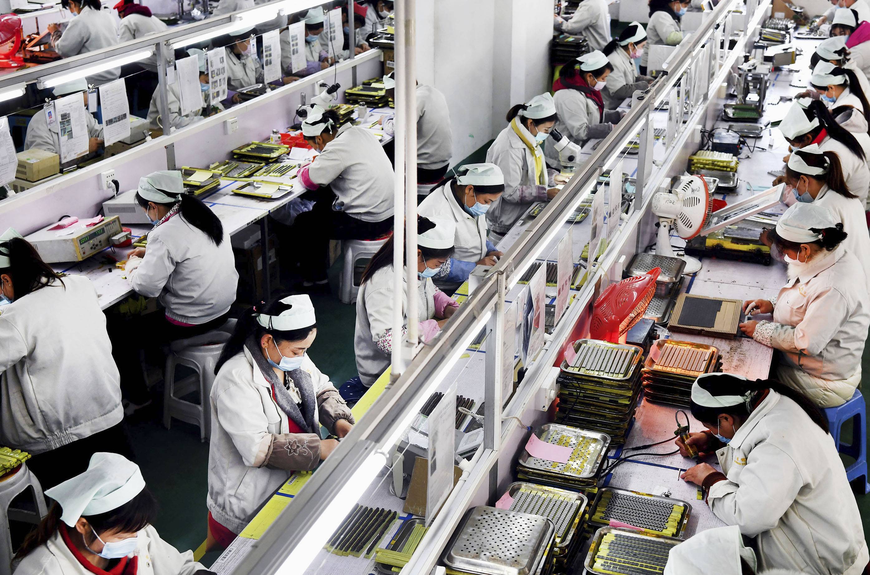 People work in a factory in China's Shaanxi Province in March. Nearly half of 96 major Japanese companies which responded to a survey said they are diversifying their supply chains to reduce reliance on China. | XINHUA NEWS AGENCY / VIA KYODO