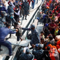 Bangladesh Navy personnel help a disabled Rohingya refugee child get off a navy vessel as they arrive at the Bhasan Char island in Noakhali district, Bangladesh, on Tuesday.  | REUTERS