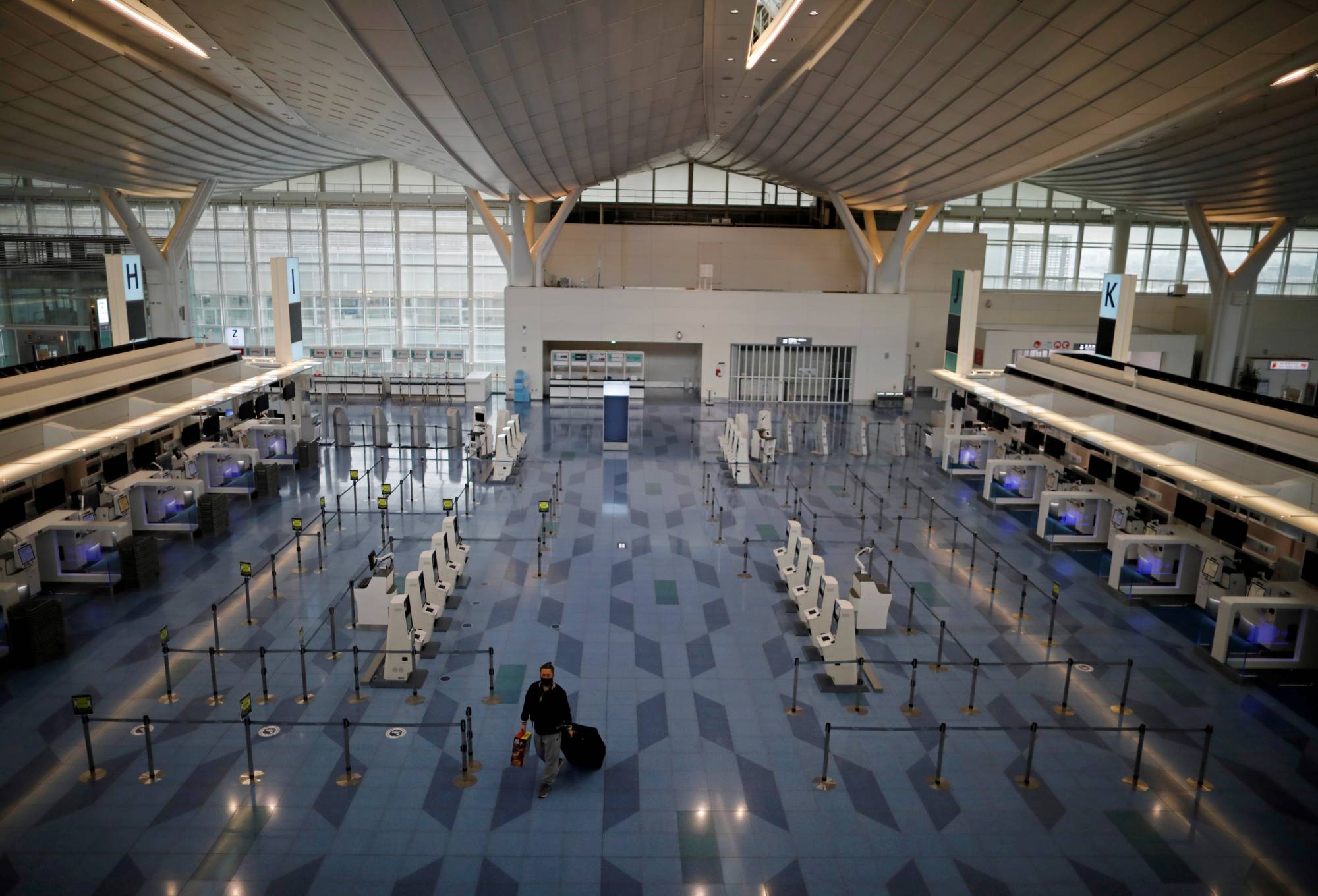 An almost empty check-in area of the international flight terminal of Haneda Airport on Monday. | REUTERS
