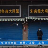 A security guard stands outside the Huanan Seafood Wholesale Market in January. | AFP-JIJI