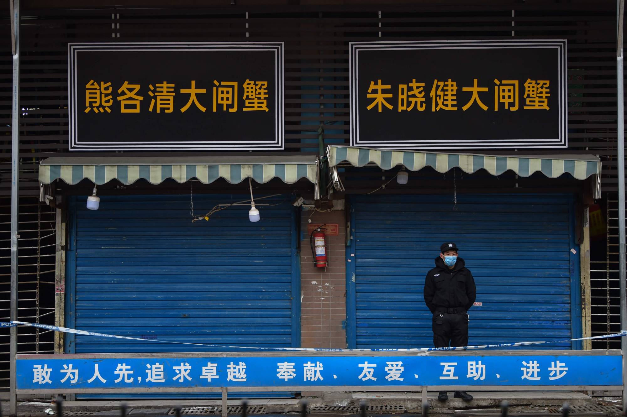 A security guard stands outside the Huanan Seafood Wholesale Market in January. | AFP-Jiji