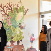 Teresa Currea (left), Oriana Marin (center) and Clara Campos (right) pose in front of a painting that represents the concept of Mother Nature and friendship. | TOMOHIRO OSAKI

