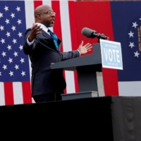 U.S. Senate candidate Rev. Raphael Warnock speaks before the arrival of U.S. President-elect Joe Biden to campaign on behalf of Jon Ossoff and himself ahead of their Tuesday runoff elections, during a drive-in campaign rally at Pullman Yard in Atlanta on Dec. 15, 2020. | REUTERS