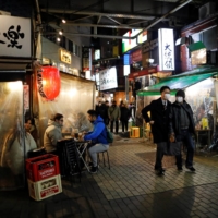 People enjoy drinking and dining at an izakaya-style pub amid the COVID-19 outbreak in Tokyo on Tuesday. | REUTERS