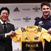New Sungoliath signing Beauden Barrett (right) receives a jersey from the team\'s senior director Masato Tsuchida during a news conference on Wednesday. | AFP-JIJI