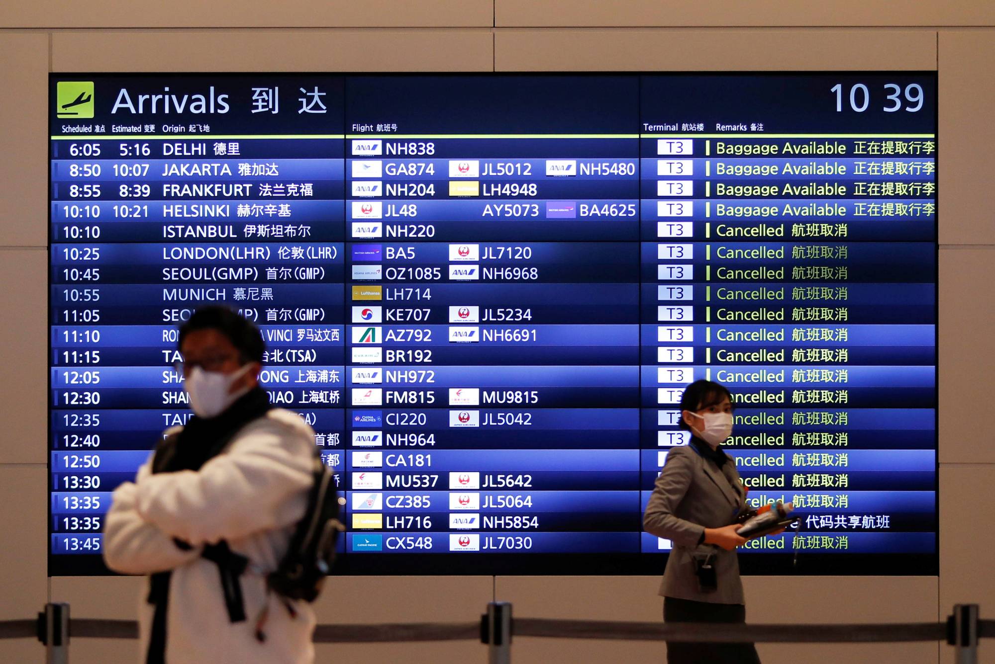 A visitor and an airline company staff member at the arrival gate of the international flight terminal at Haneda Airport in Tokyo amid the coronavirus pandemic on Dec. 28 | REUTERS
