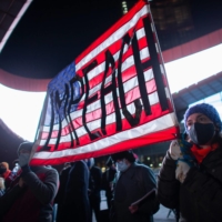 Demonstrators hold a banner calling for impeachment of U.S. President Donald Trump during a protest outside the Barclays Center in Brooklyn, New York on Thursday. | AFP-JIJI