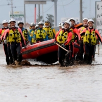 Rescue workers search a flooded area in the aftermath of Typhoon Hagibis, which caused severe floods at the Chikuma River in Nagano Prefecture in October 2019. | REUTERS