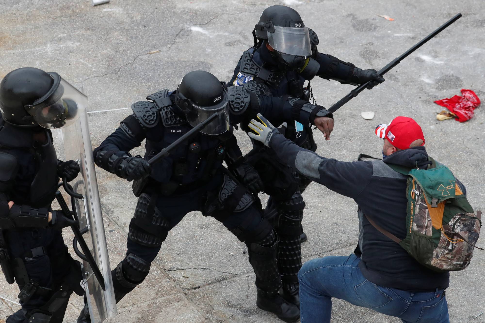 Police officers wield their batons against a man as pro-Trump rioters storm into the U.S. Capitol on Wednesday. | Reuters 