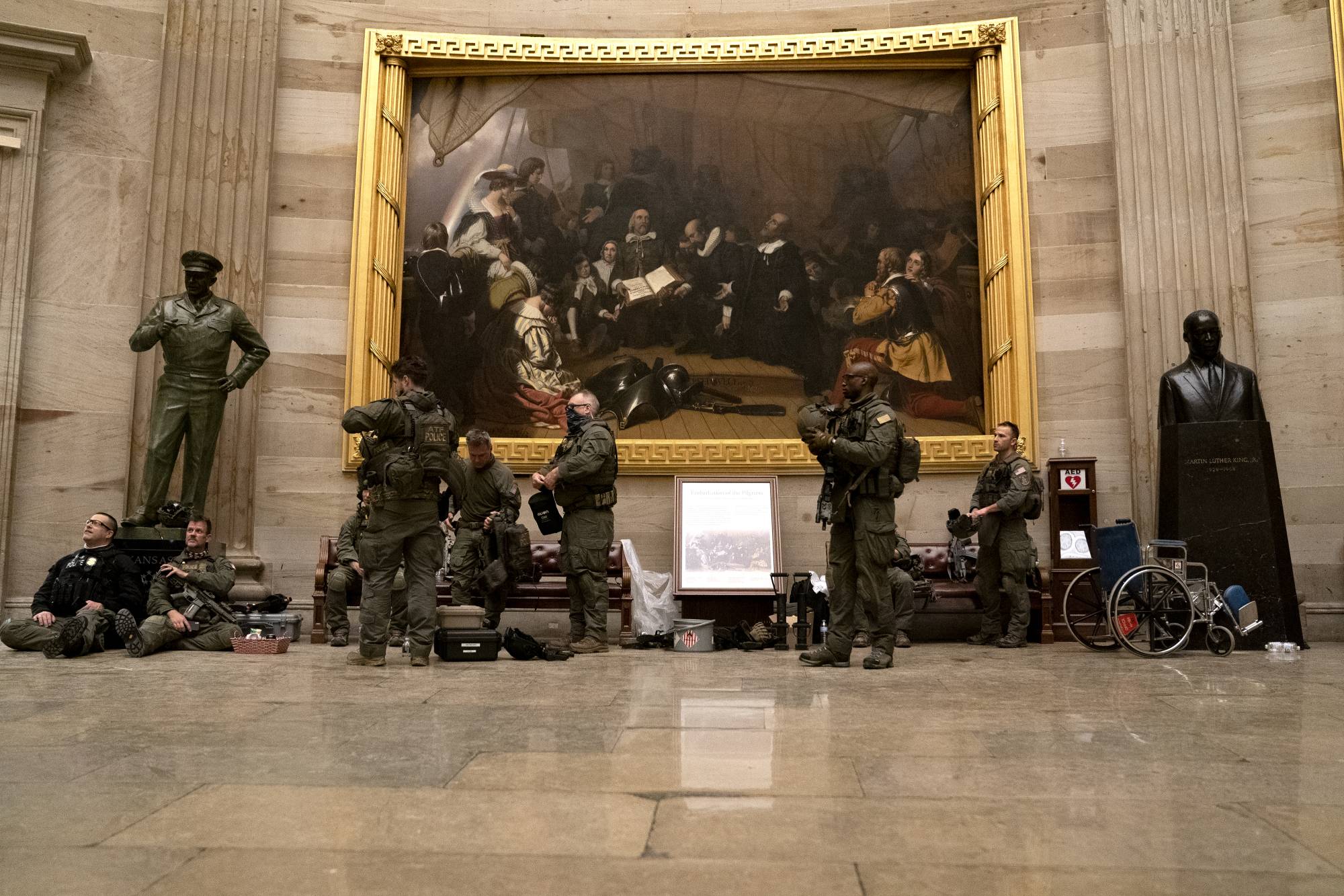 Police in riot gear sit in the rotunda of the U.S. Capitol in Washington on Wednesday. | Bloomberg 