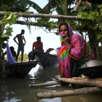 A flood-affected woman sits on a structure made of bamboo, as her house has been flooded, in Bogura, Bangladesh, in July. Bangladesh\'s \"Delta Plan 2100\" aims to tackle flood and drought risks in hot spots along its major rivers and coastlines. | REUTERS