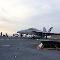 A U.S. Navy sailor guides an F/A-18F Super Hornet onto the electromagnetic launching system, which replaces the steam-piston catapult, on the aircraft carrier USS Gerald R. Ford in the Atlantic Ocean in July 2017. | U.S. NAVY / VIA REUTERS