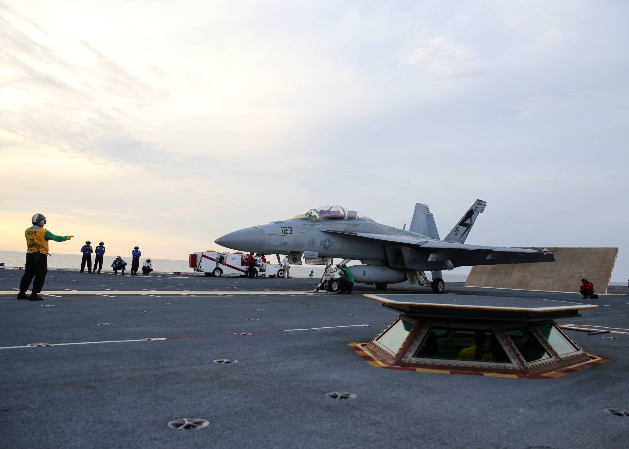 A U.S. Navy sailor guides an F/A-18F Super Hornet onto the electromagnetic launching system, which replaces the steam-piston catapult, on the aircraft carrier USS Gerald R. Ford in the Atlantic Ocean in July 2017. | U.S. Navy / via REUTERS