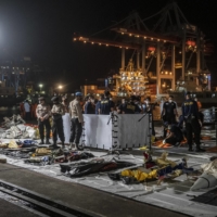 Indonesian authorities examine remnants of Sriwijaya Air flight SJ-182 at Tanjung Priok Port in Jakarta on Monday.  | ULET IFANSASTI / THE NEW YORK TIMES