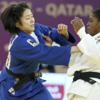 Tsukasa Yoshida (left) competes against Sarah Leonie Cysique in the women\'s under-57 kg final at the International Judo Federation World Masters in Doha on Monday. | INTERNATIONAL JUDO FEDERATION / VIA KYODO