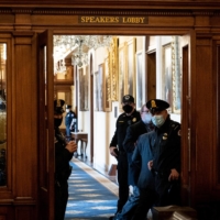 Capitol police stand guard at the Speakers Lobby of the House chamber at the Capitol in Washington on Monday, Jan. 11, 2021, where glass remains broken in the wake of the riot in the building last week. Major U.S. corporations are vowing to pull their campaign contributions after Republicans in Congress tried to overturn President-elect Joe Biden\'s electoral victory. | ERIN SCHAFF/THE NEW YORK TIMES
