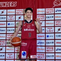 High school senior Reoto Yonesu, who will join the Brave Thunders as a  poses during a news conference on a specially-designated player contract, poses for photos during a news conference on Wednesday. | KAZ NAGATSUKA
