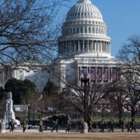 Members of the National Guard walk in front of the U.S. Capitol in Washington on Wednesday.  | BLOOMBERG