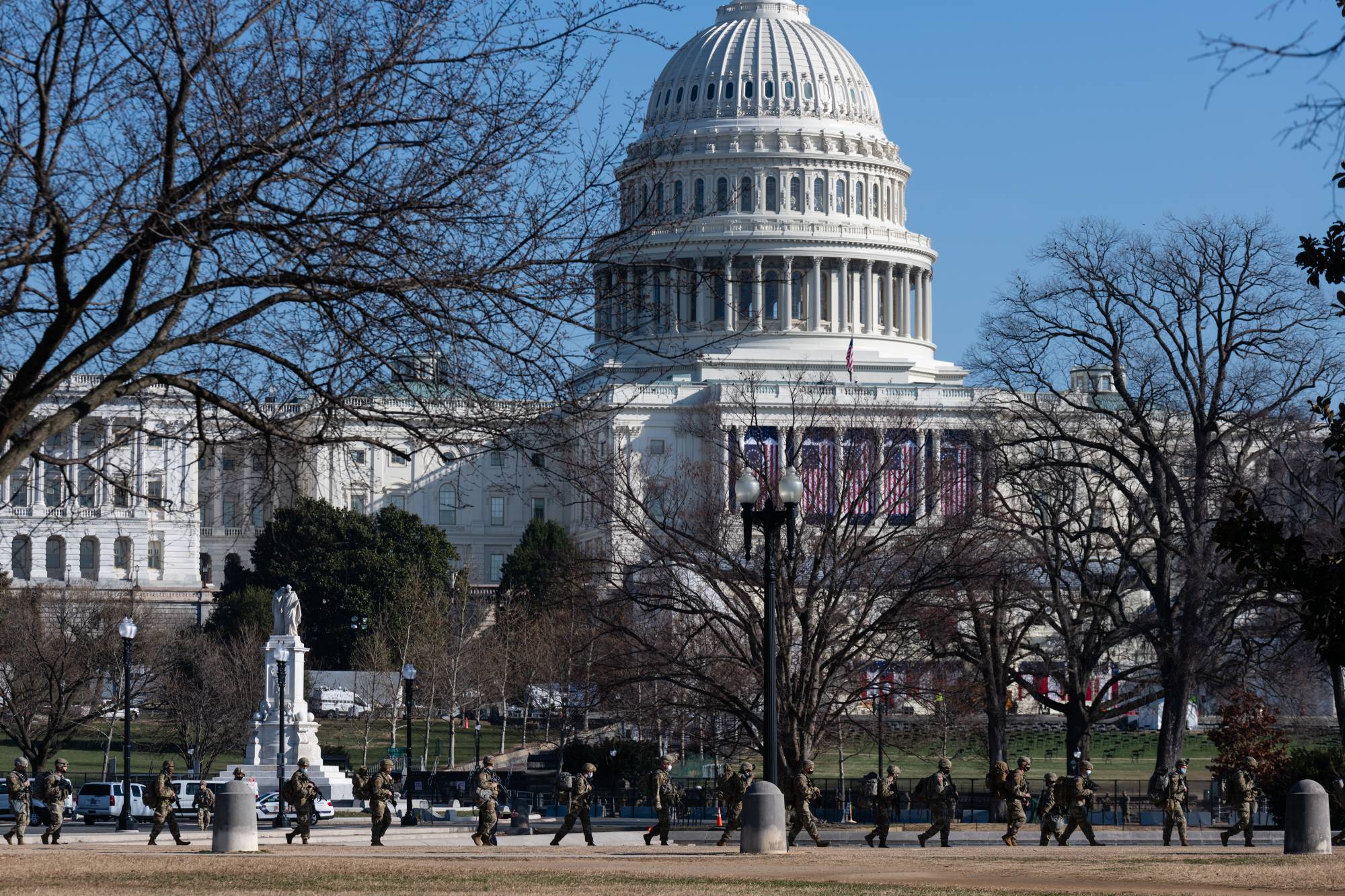 Members of the National Guard walk in front of the U.S. Capitol in Washington on Wednesday.  | BLOOMBERG