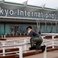People wait at the international flight terminal at Haneda Airport on Dec. 28 last year. | REUTERS