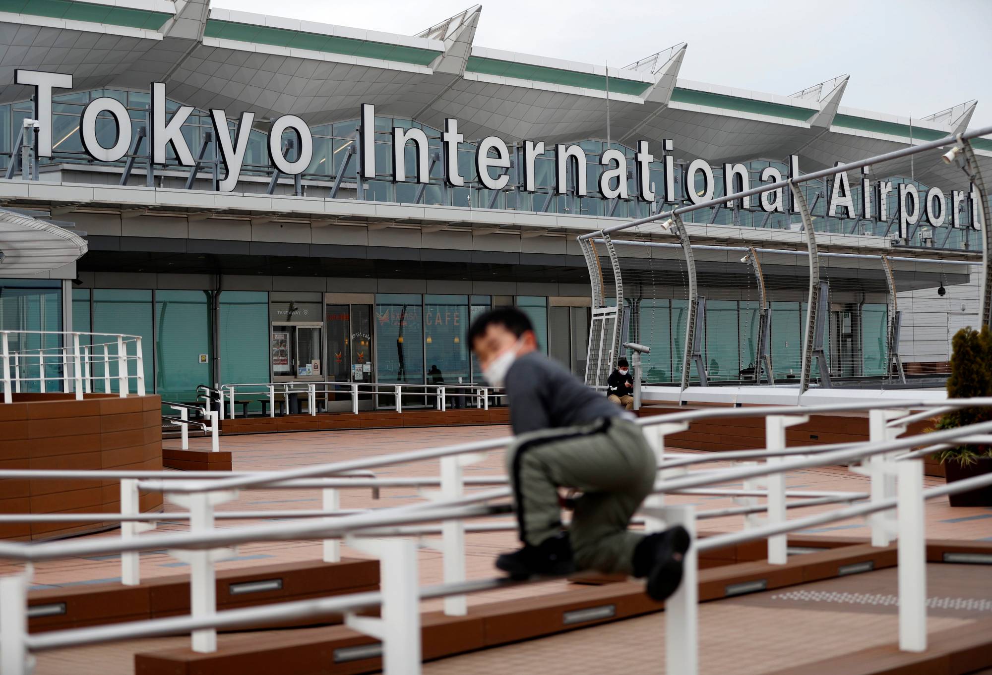 People wait at the international flight terminal at Haneda Airport on Dec. 28 last year. | REUTERS