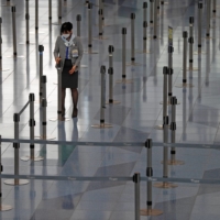 A staff member at an airline company works at the check-in area of the international flight terminal at Haneda Airport on Dec. 28 last year. | REUTERS