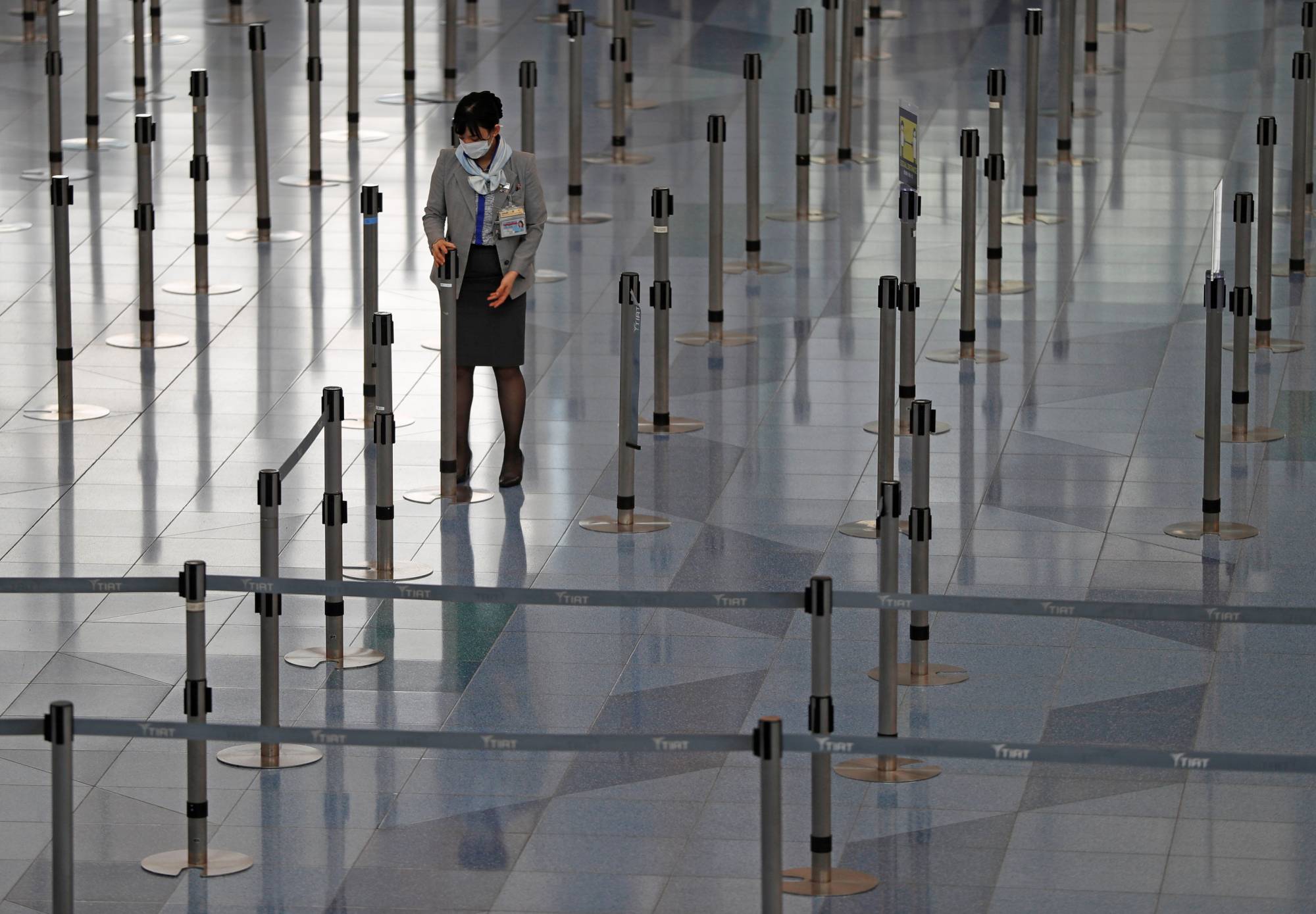A staff member at an airline company works at the check-in area of the international flight terminal at Haneda Airport on Dec. 28 last year. | REUTERS