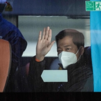 A member of the World Health Organization team investigating the origins of the COVID-19 pandemic sits on a bus following the team\'s arrival in Wuhan on Thursday. | AFP-JIJI