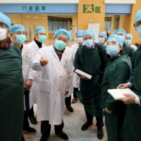 Experts from China and a World Health Organization team visit Wuhan Tongji Hospital in February last year.  | CHINA DAILY / VIA REUTERS