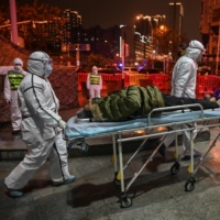 Medical staff members bring a patient to a Wuhan hospital in January last year. Seemingly worried about drawing renewed attention to the country’s early mistakes in handling the pandemic, Chinese officials have used a variety of tactics over the past year to hinder the WHO investigation into the origins of COVID-19.  | AFP-JIJI
