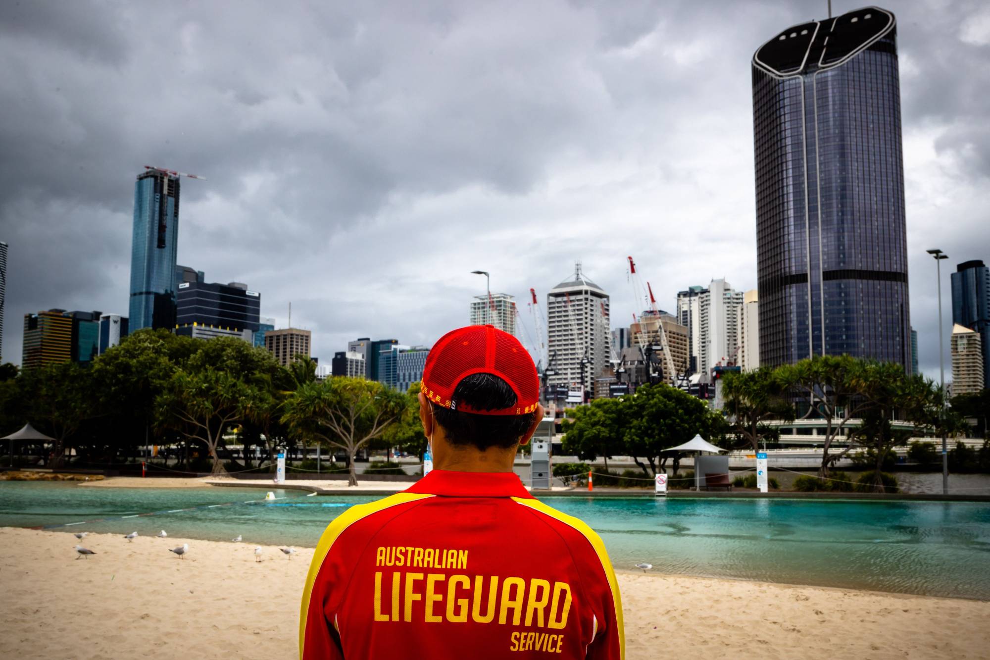 A lifeguard stands watch over a deserted South Bank beach on the first day of a snap lockdown in Brisbane on Jan. 9. Australia expects to approve the vaccine developed by Pfizer Inc. and BioNTech SE by the end of January and the AstraZeneca Plc vaccine next month, with shots also beginning in February. | AFP-JIJI